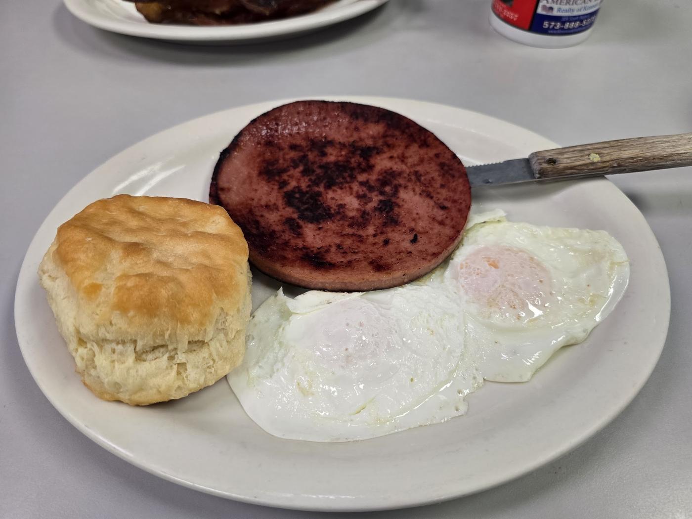 Fried bologna with a biscuit and a fried egg