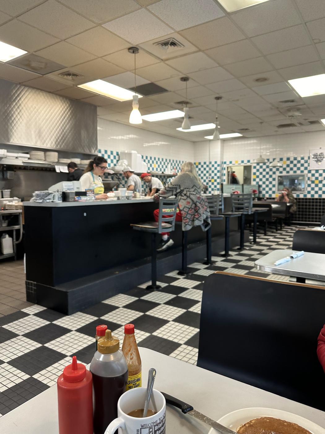 The dining room with black booths and a black and white checkered floor